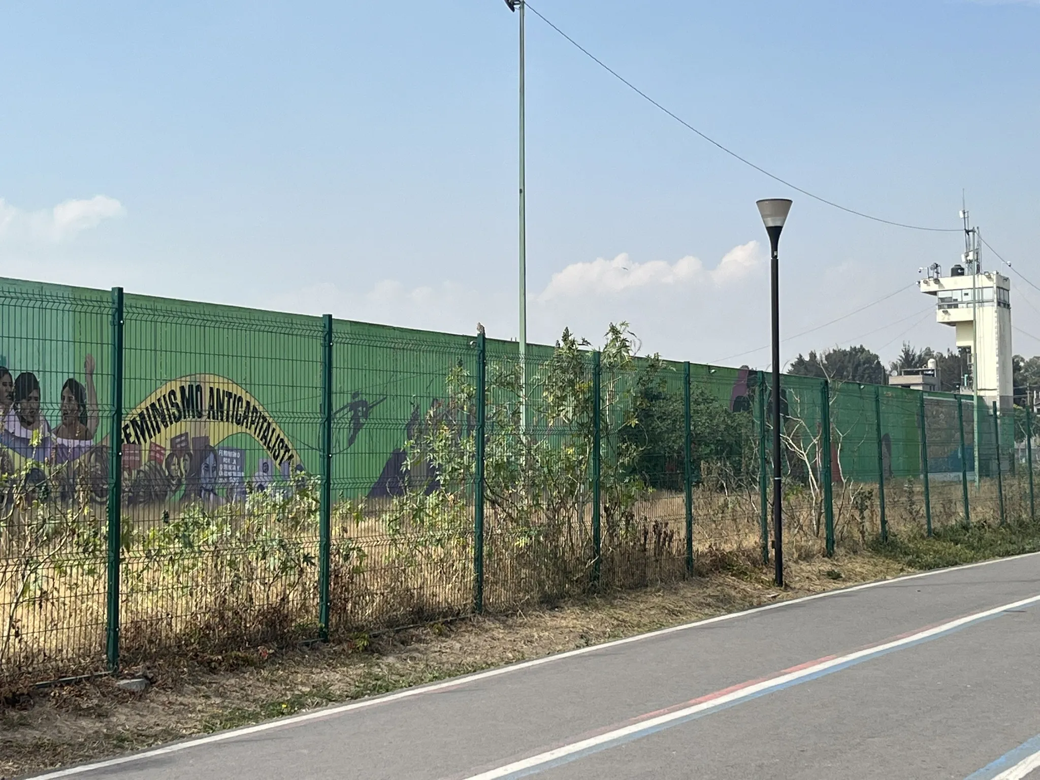 The wall between UTOPIA La Libertad and the prison, el Reclusorio Preventivo Varonil Oriente, is adorned with Indigenous anti-capitalist iconography. Photo courtesy of the author.
